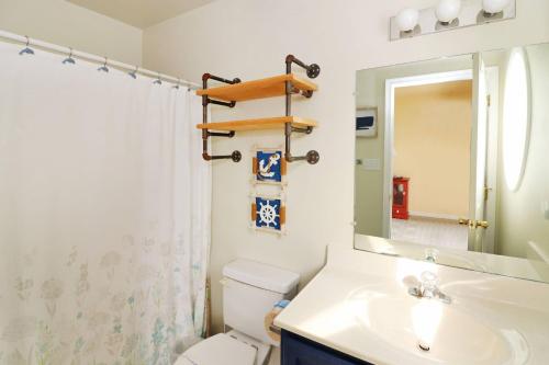 un bagno con lavandino, WC e specchio di Bay Daze - Waterfront townhome w private boat dock! a Chincoteague