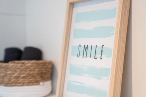 a clipboard with the word smile next to a basket at Küstenbutze im Beach-Style 2 Bedrooms, 2 Bäder , Garten, Terrasse, Top-Modern in Mildstedt