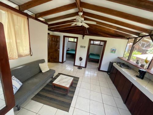 a living room with a couch and a ceiling fan at Perla Negra Beachfront in Puerto Viejo