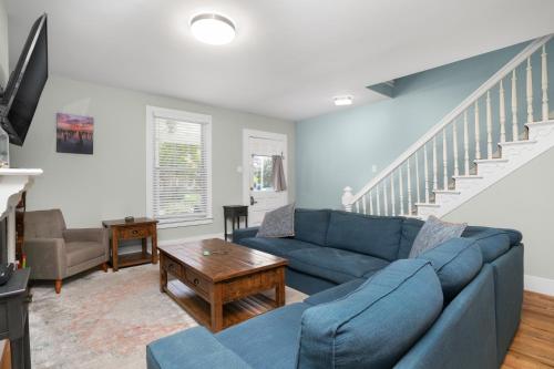 a living room with a blue couch and a table at Bayside - Classic duplex in historic downtown! in Cape Charles