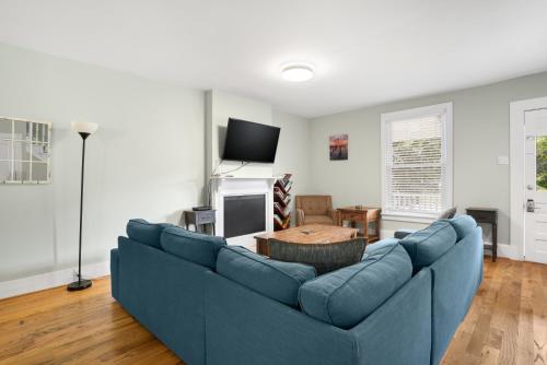 a living room with a blue couch and a tv at Bayside - Classic duplex in historic downtown! in Cape Charles