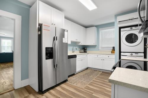 a kitchen with a refrigerator and a washer and dryer at Bayside - Classic duplex in historic downtown! in Cape Charles
