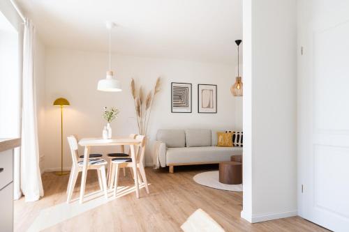 a white living room with a table and chairs at Küstenbutze im modernen Scandi-Style mit Garten und Terrasse in Mildstedt