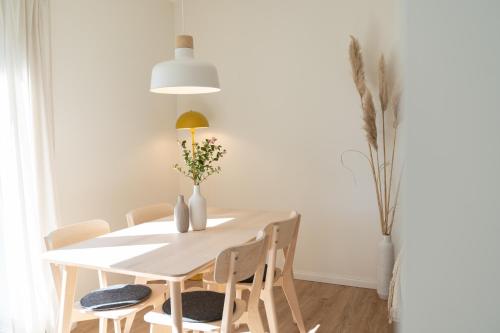 a dining room with a white table and chairs at Küstenbutze im modernen Scandi-Style mit Garten und Terrasse in Mildstedt