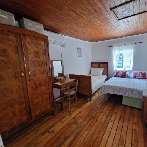a bedroom with a bed and a desk with a table at RELAXED PLACE by the sea in Cesarica