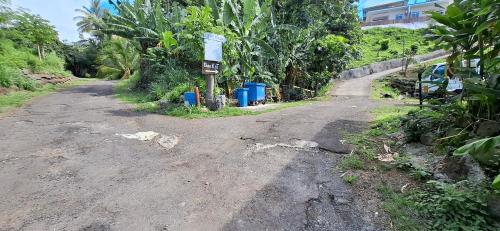 a dirt road with a sign on the side of it at Fare KnT in Faaa