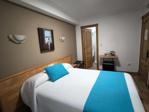 a bedroom with a bed with a blue pillow on it at Hostería VISTAPARK in El Astillero