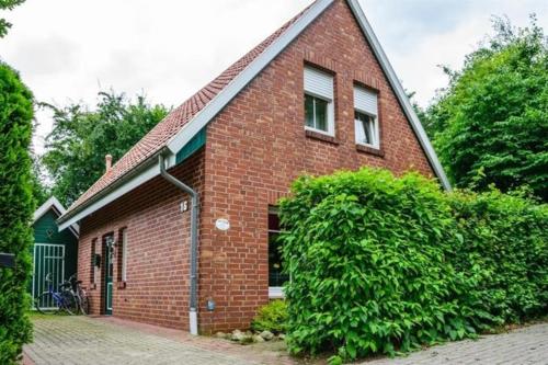 a red brick house with a green garage at Hümmling HA16 in Sögel