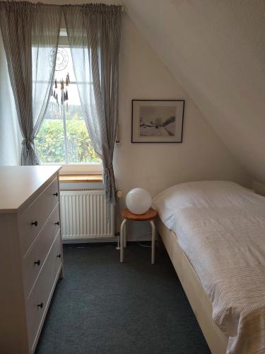 a bedroom with a bed and a dresser and a window at Hümmling HA16 in Sögel