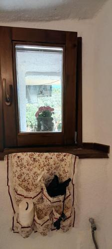 a window above a bed with a pillow with a flower pattern at B&B 8A CASTELBIANCO in Castelbianco