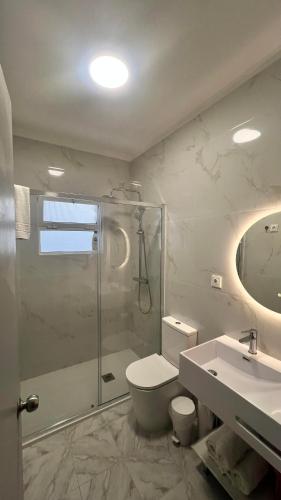 a bathroom with a shower and a toilet and a sink at Santo Cristo House in Ponta Delgada