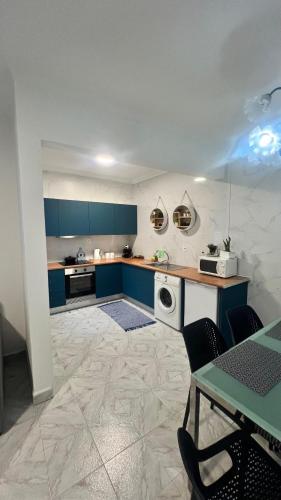 a kitchen with blue cabinets and a table with chairs at Santo Cristo House in Ponta Delgada