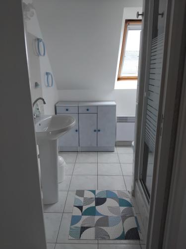 La salle de bains est pourvue d'un lavabo, de toilettes et d'un tapis. dans l'établissement Charmante maison à la Turballe proche de la plage, entre Guérande et Piriac, à La Turballe