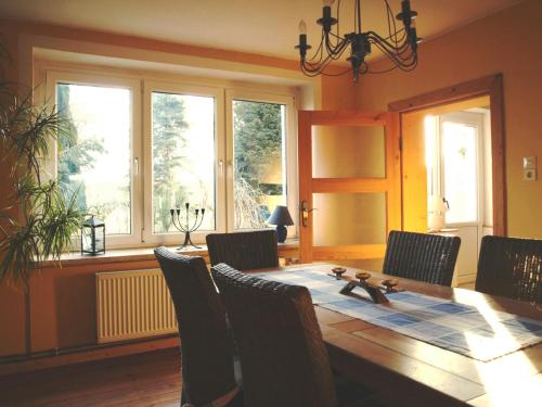 a dining room with a table and chairs and windows at Ferienwohnung Land Fleesensee 659-01 in Göhren-Lebbin