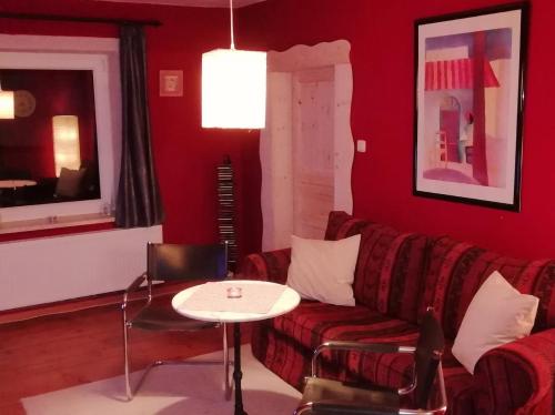 a red living room with a couch and a table at Ferienwohnung Land Fleesensee 659-01 in Göhren-Lebbin