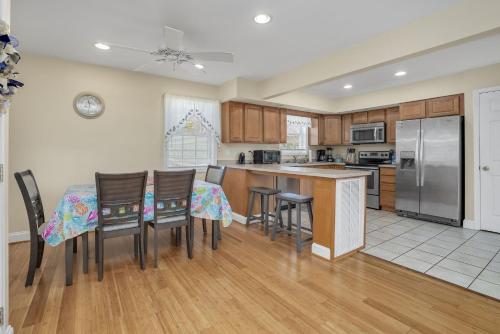 a kitchen with a table and chairs and a refrigerator at Beach Haven - Modern Home; Close to town! in Chincoteague