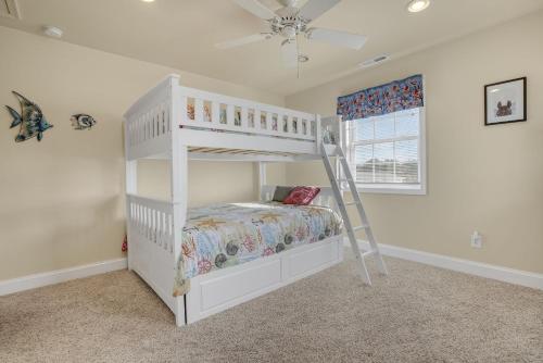 a white bunk bed in a room with a ladder at Beach Haven - Modern Home; Close to town! in Chincoteague