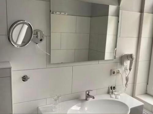 a bathroom with a sink and a mirror at MiLANO Seehotel in Krakow am See