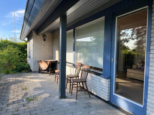 a patio with two chairs and a table and windows at Hyggelige 200kvm villa udenfor køge tæt på strand in Køge