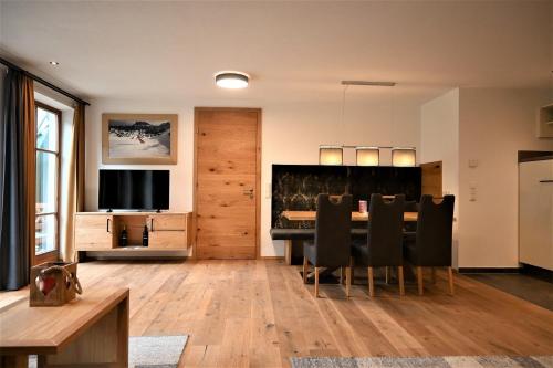 a dining room with a table and chairs and a television at Apartment Grubigstein in Biberwier