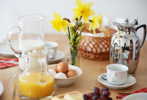 einem Tisch mit Eiern und einem Krug Orangensaft und Blumen in der Unterkunft Bauernhof Höper-Rauert - Reihenhaus 8 in Neujellingsdorf