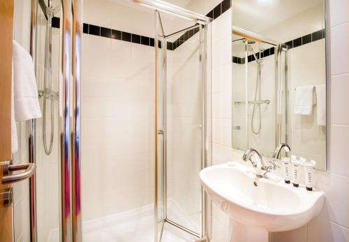 
a bathroom with a shower, sink, and mirror at Cork International Hotel in Cork
