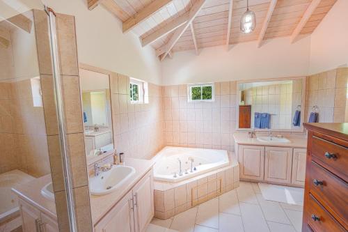 a bathroom with two sinks and a tub and a shower at Sweet Home Grenada Caribbean in Lance aux Épines