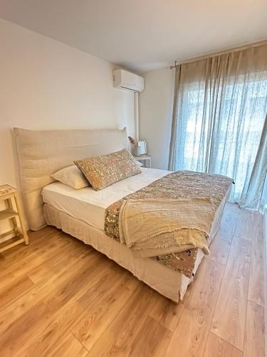 une chambre avec un grand lit avec un plancher en bois dans l'établissement Appartement plein centre vue mer PROPRIANO, à Propriano