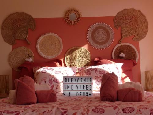 a bedroom with a bed with a red head board at Une virée à deux, gîte et spa in Guiscard