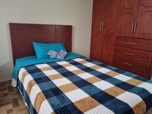 a bedroom with a bed with a blue and white quilt at Edificio K&C in Sogamoso