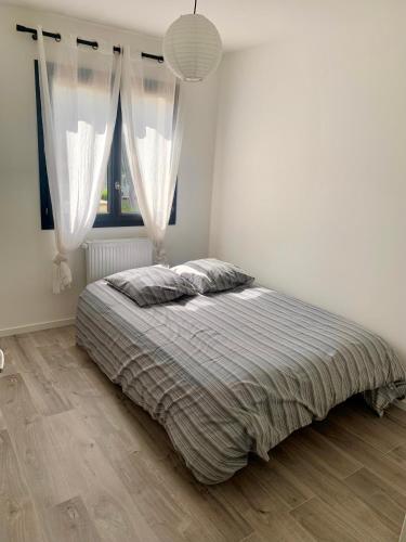 une chambre avec un lit et une grande fenêtre dans l'établissement 5mn Crolles Chambre au calme parking gratuit - belle cuisine partagée, à Froges