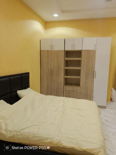 a bedroom with a bed and some cabinets at Rich Garden Homes Shortlet Apartment in Ikota