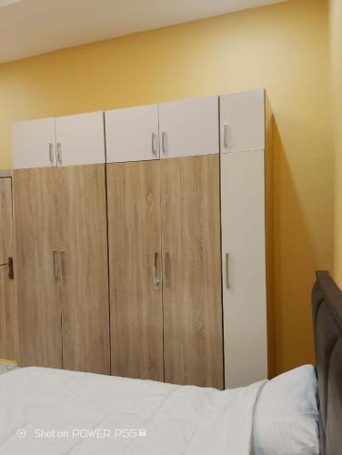a bedroom with brown and white cabinets and a bed at Rich Garden Homes Shortlet Apartment in Ikota