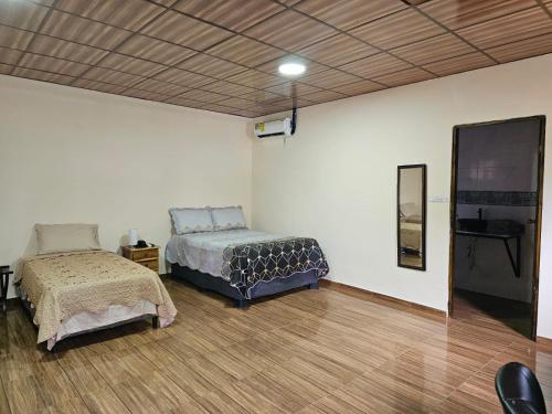 AserríoPleasant Hostal Panama的一间卧室，里面有两张床和一台电视