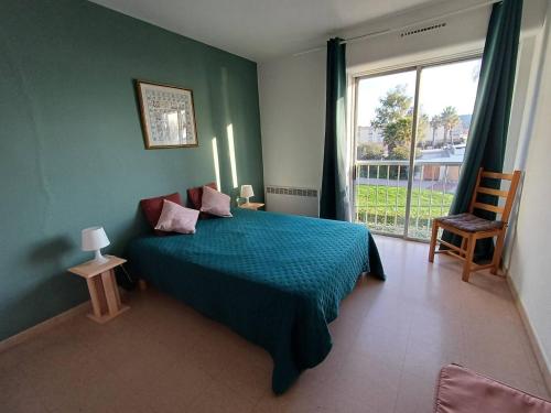 une chambre avec un lit bleu et une fenêtre dans l'établissement F2 2 étoiles avec clim, ascenseur, proche Thermal - Balaruc-les-Bains - FR-1-571-63, à Balaruc-les-Bains