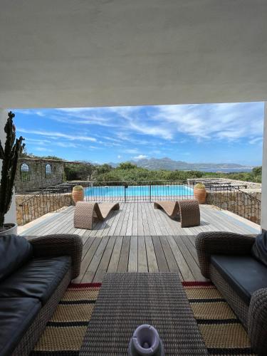 a view of a swimming pool from the deck of a house at Clos des Oliviers in Lumio
