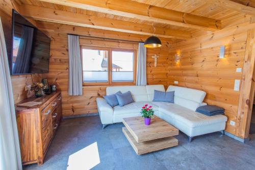 a living room with a couch and a table at Chalet Huber by Alpenidyll Apartments in Gössenberg