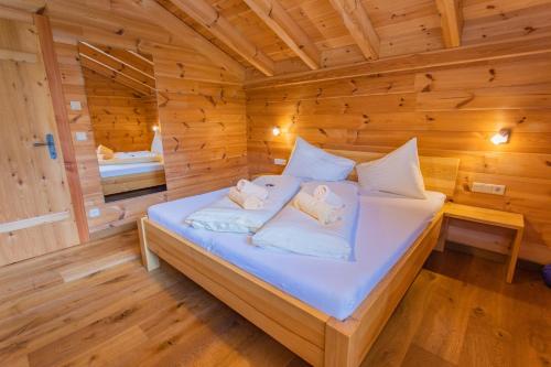 a bedroom with a bed in a wooden cabin at Chalet Huber by Alpenidyll Apartments in Gössenberg