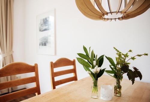 einen Esstisch mit zwei Vasen mit Blumen darauf in der Unterkunft Bauernhof Höper-Rauert - Reihenhaus 4 in Neujellingsdorf