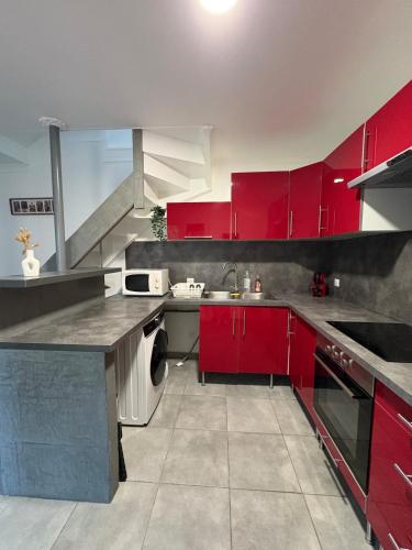 une grande cuisine avec des placards rouges et un évier dans l'établissement Laparté en Provence, à Saint-Martin-de-Crau