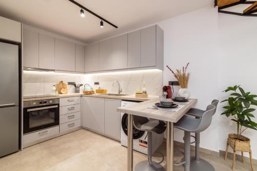 a kitchen with white cabinets and a table and chairs at Elena's by the sea maisonette in Zakynthos Town