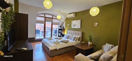 a bedroom with a bed and a living room at Fotiadis - Cosy apartments and spectacular rooms in Veliko Tŭrnovo