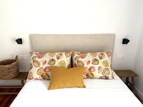 a bed with two pillows and a headboard at GURAH Boutique Apartments in Bakio