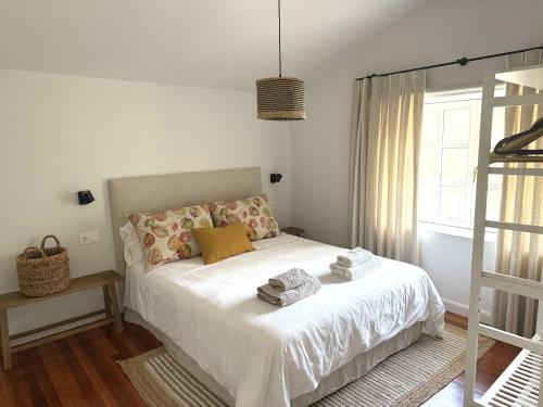 a bedroom with a bed with white sheets and a window at GURAH Boutique Apartments in Bakio