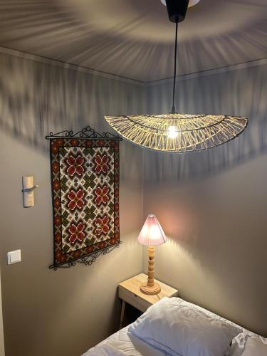 a bedroom with a lamp and a quilt on the wall at Leilighet i 1 etg Røldal in Håra