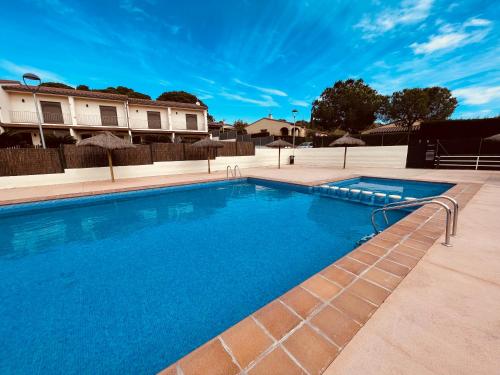einen Pool mit blauem Wasser vor einem Haus in der Unterkunft Sa Tina - Casa con encanto en la Costa Brava L'Estartit in Torroella de Montgrí