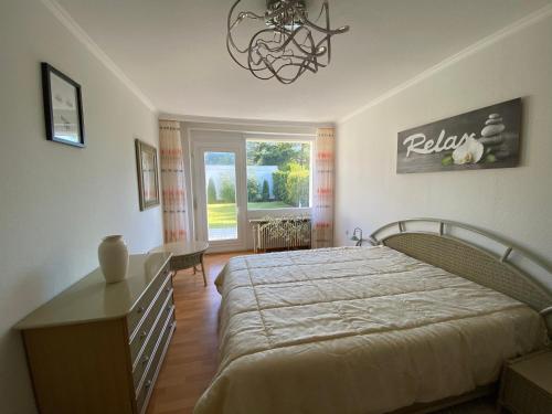 a bedroom with a bed and a table and a window at Ferienhaus direkt an der Luhe in Winsen Luhe