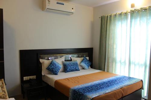 a bedroom with a bed with blue and white pillows at Mount Residency in Chennai