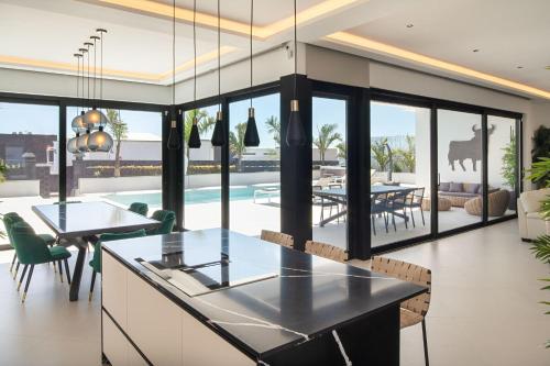 an open kitchen and dining room with a view of a pool at TORO by Buenavilla in Puerto Calero