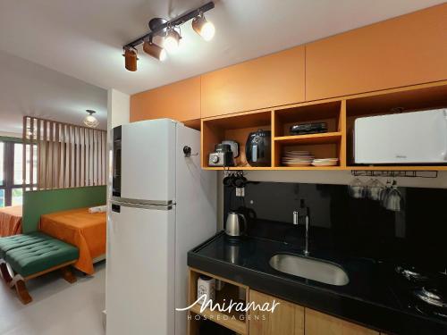 a kitchen with a refrigerator and a sink at Vert House Jardim Oceania - Miramar Hospedagens in Tambaú